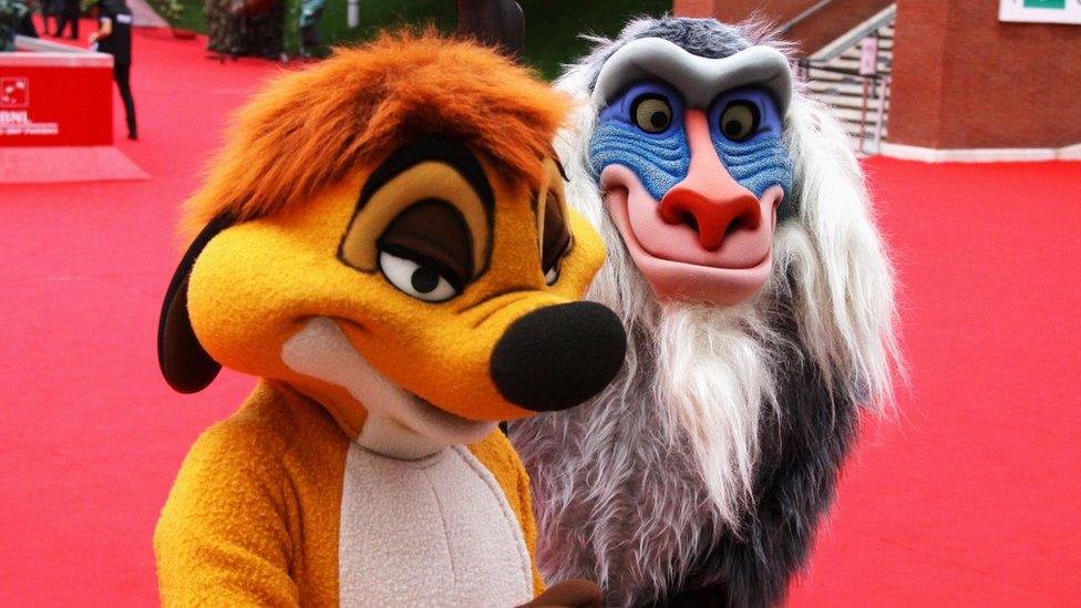 Two people dressed as characters from the lion king.