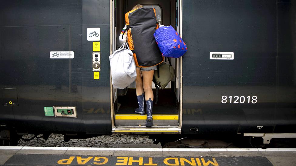 A woman boards a train at Paddington station, London, on 23 June 2022