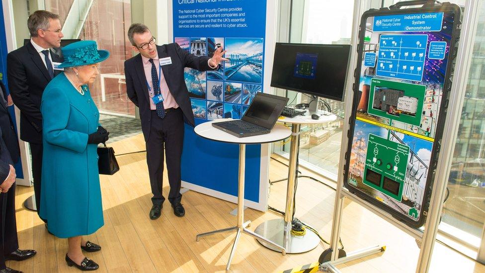 Alex Dewdney (right) gives the Queen a demonstration of how an electricity supply could be subjected to cyber attack