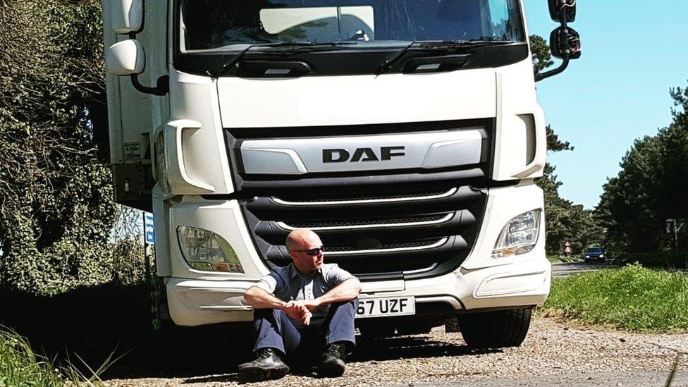 Tom Reddy sat in front of a parked lorry