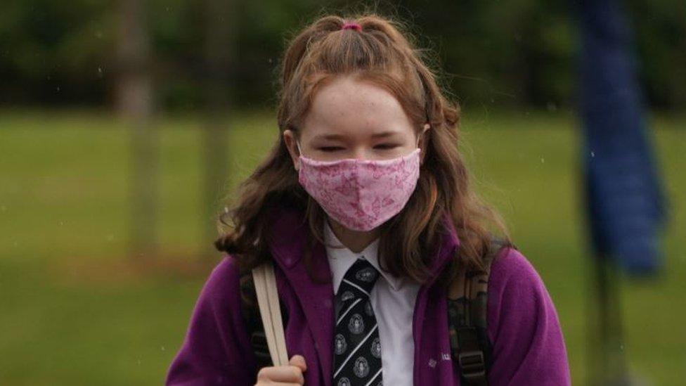 A pupil wearing a face covering arrives at Kelso High School on the Scottish Borders as schools in Scotland start reopening on Tuesday