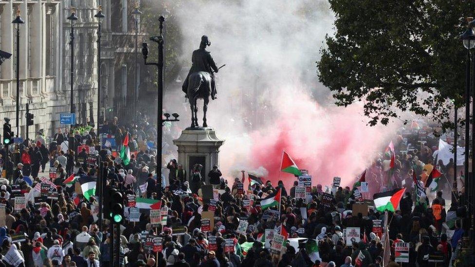 Demonstrators protest in solidarity with Palestinians in central London, flares have been set off and flags are being waves