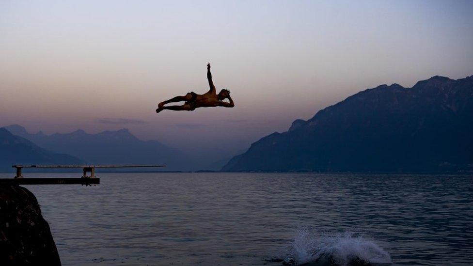 People cool down at sunset in Lake Geneva - 26 June