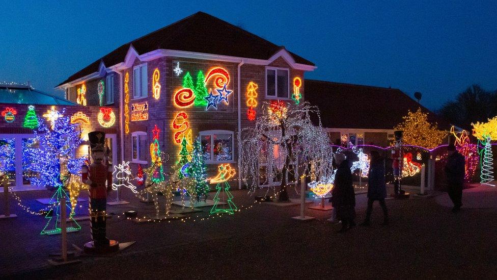 The outside of a house heavily decorated with Christmas lights.