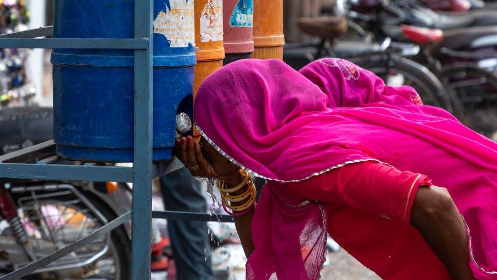 A Rajasthani woman drinks water