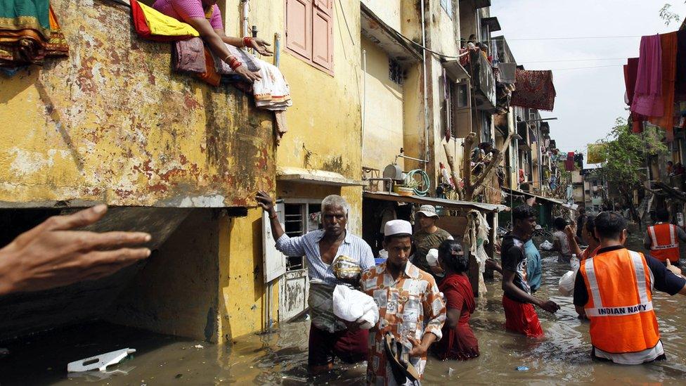 People receive food packets distributed by navy personnel in Chennai,