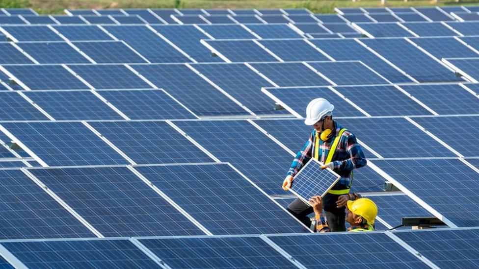 Technicians fitting solar panels