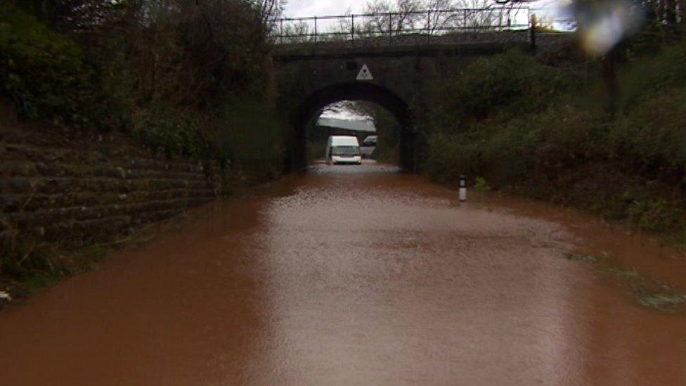 A van is stuck in a flooded road