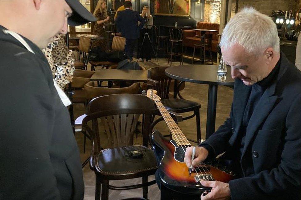 Sting signing a fan's guitar