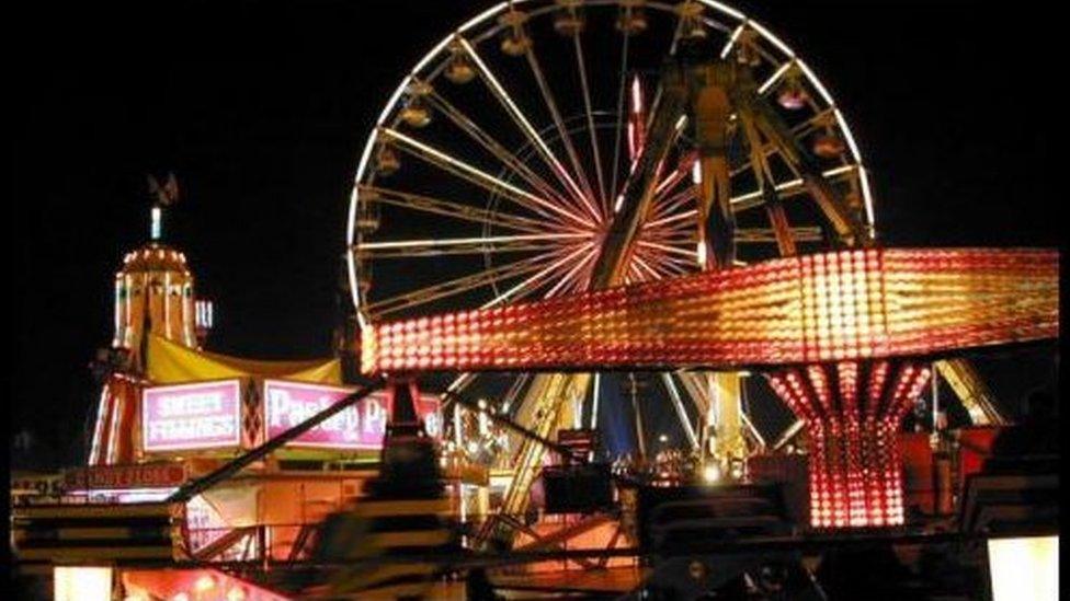 Night shot of a fairground with big wheel and roundabout