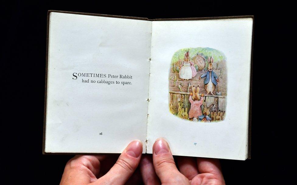 An assistant holds a first edition of The Flopsy Bunnies by Beatrix Potter at Dreweatts and Bloomsbury Auctions in 2017