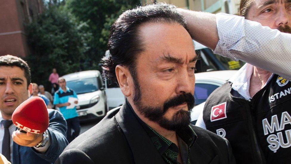 Turkish police officers escort televangelist and leader of a sect, Adnan Oktar (C) on July 11, 2018, in Istanbul, as he is detained on fraud charges.