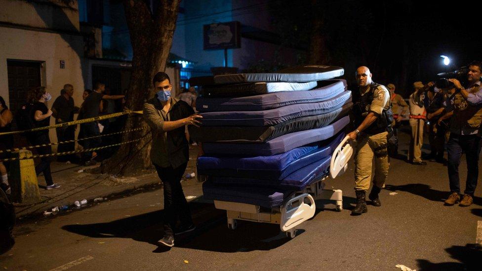 Men carry mats to ambulances transferring patients during a fire at the Badim private Hospital in Tijuca neighborhood, Rio de Janeiro, Brazil, on September 12, 2019