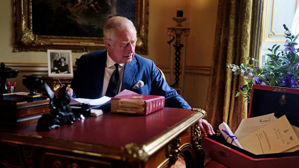 King Charles III with red box (ministerial despatch box) carrying out official government duties as Monarch at Buckingham Palace