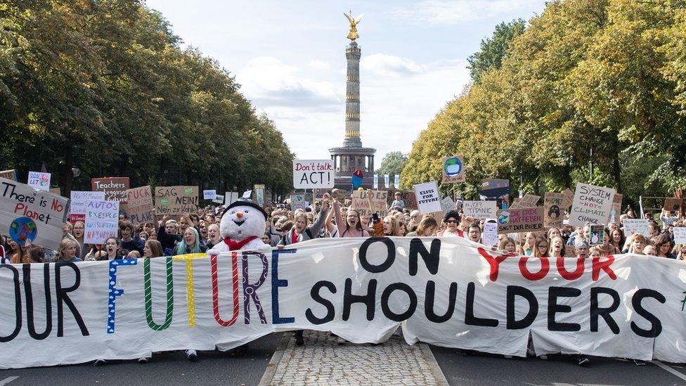 Protesters with a banner "Our future on your shoulders" attend a demonstration at the Victory Column