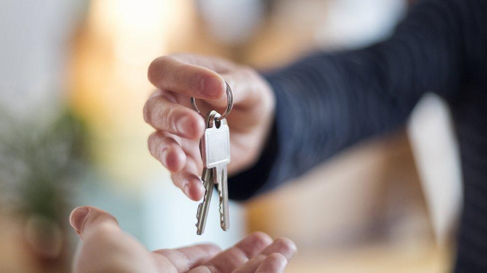 Close-up of hand over of house key in new home