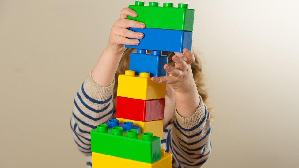 A toddler with toy bricks