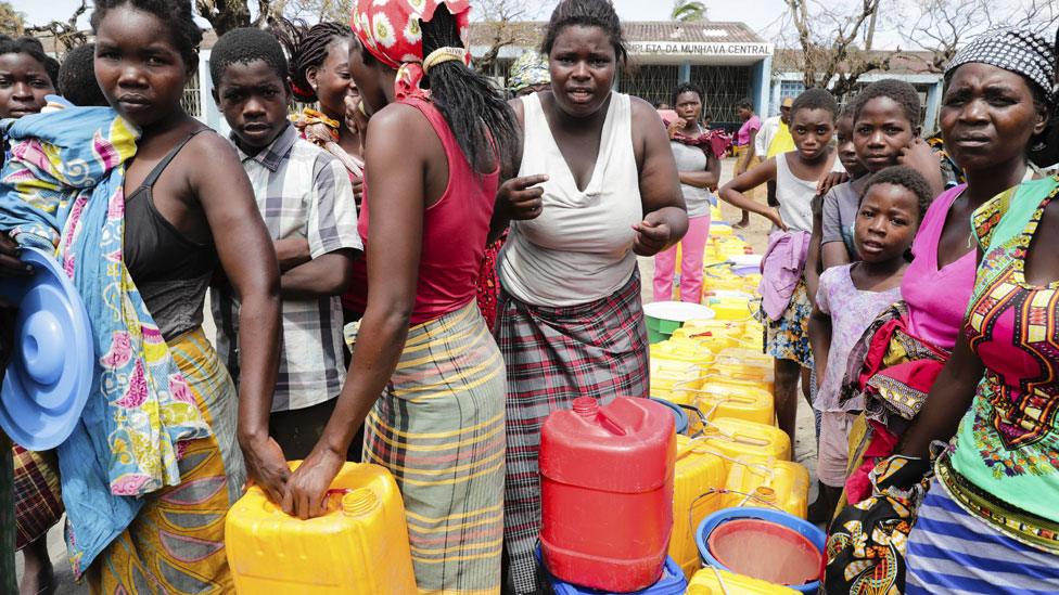 People wait to collect drinkable water delivered by local authorities after the cut on public supply of water that followed the passage of the cyclone Idai in Beira City, central Mozambique, 21 March 2019.