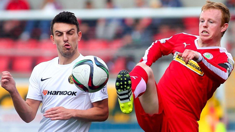 Conor McCloskey of Carrick Rangers in action against George McMullan who scored the goal in Cliftonville's 1-0 home victory