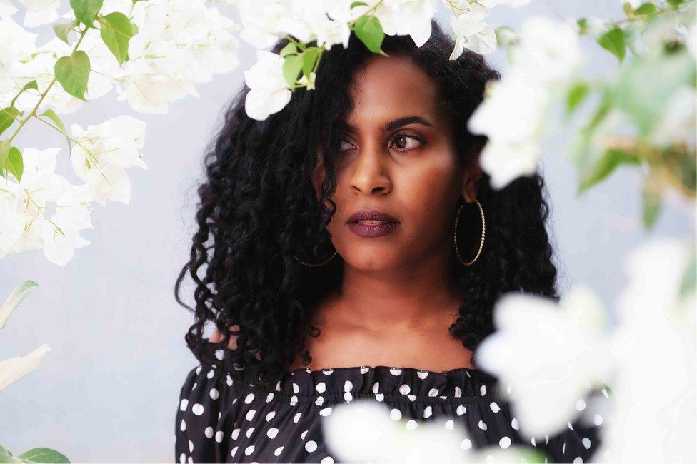 A portrait of a woman framed with white flowers