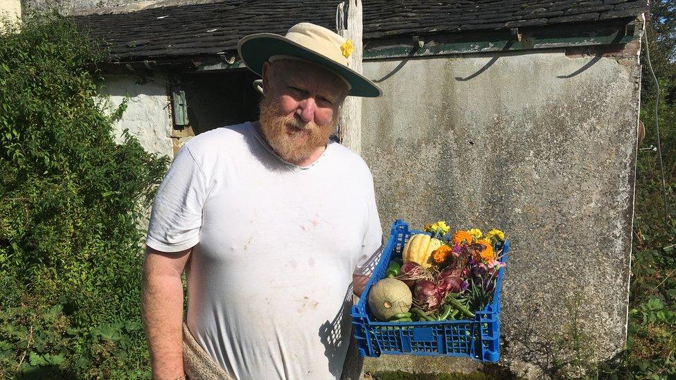 Barry George holding a crate of vegetables