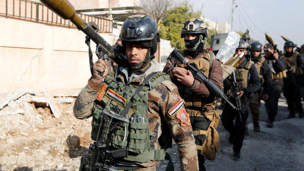 Iraqi Special Operations Forces (ISOF) carry weapons during clashes with so-called Islamic State (IS) near Mosul University, 13 January 2017