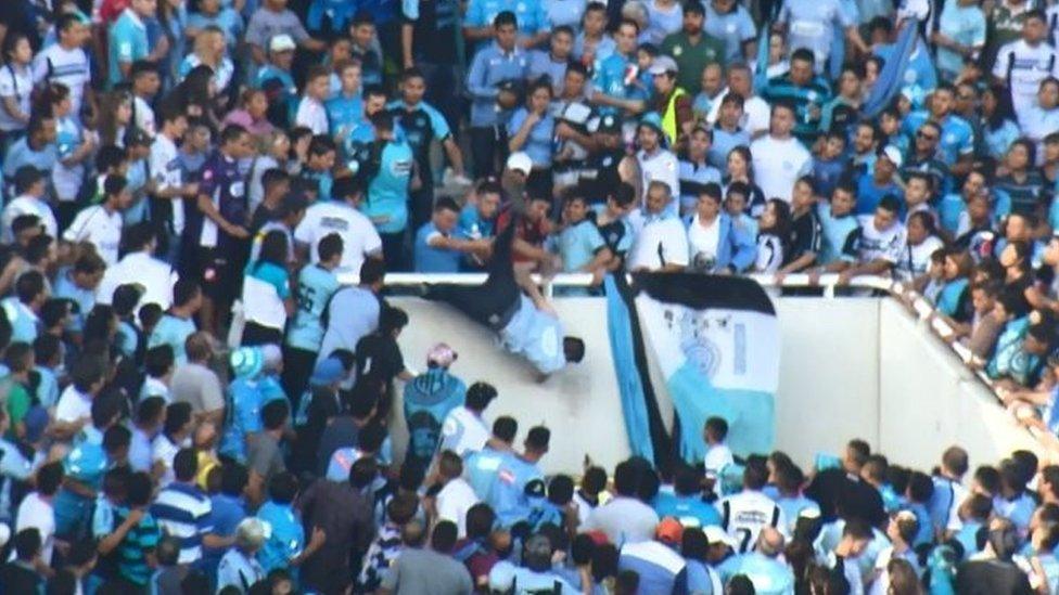 Emanuel Balbo (centre) falls from a stand in Cordoba, Argentina