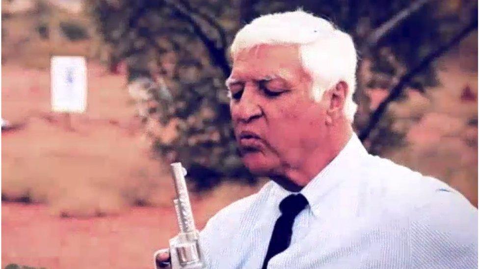 Bob Katter blows smoke away from a toy gun