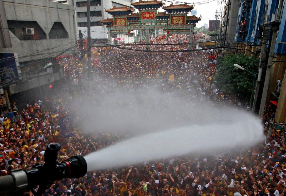 A fire hose douses the crowd with water. Manila, Philippines, 9 January 2017.