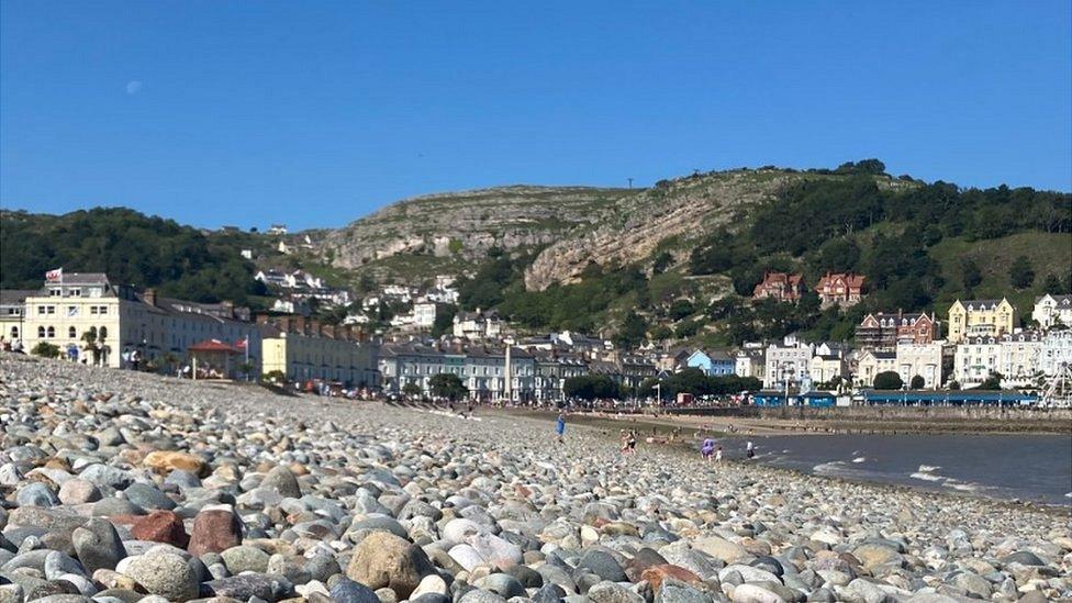 Llandudno's North Shore Beach covered in pebbles with the promenade in the background