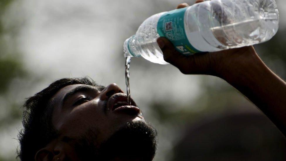 boy drinking from a bottle of water