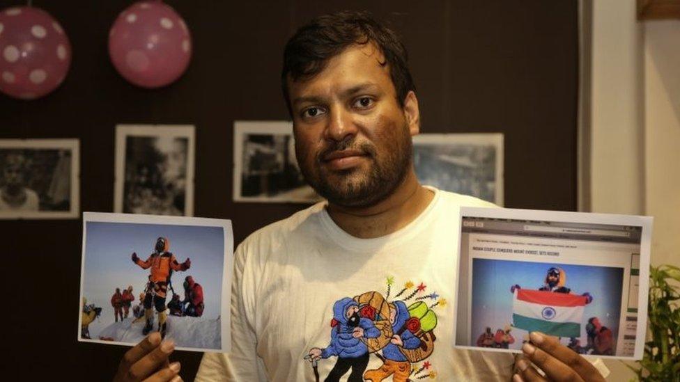 Indian climber Satyarup Sidhantha holds in his right hand a photograph that shows him on Mount Everest, along with what he says is an altered version of the same used by an Indian couple to make it appear they were on the summit (04 July 2016)