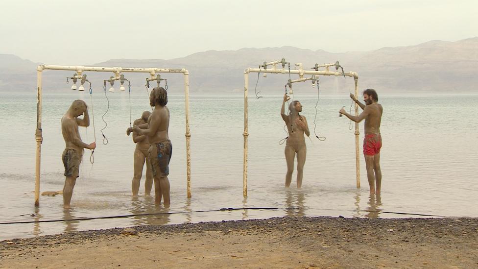 Visitors rinse the Dead Sea water and mud off themselves in public showers