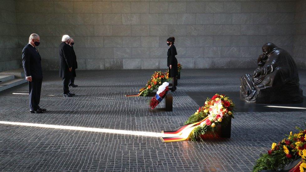 The Prince of Wales and German President Frank-Walter Steinmeier stand in silence with other dignitaries