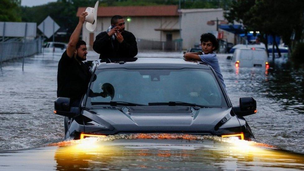 Residents use a truck to navigate through flood waters from Tropical Storm Harvey in Houston (27 August 2017)