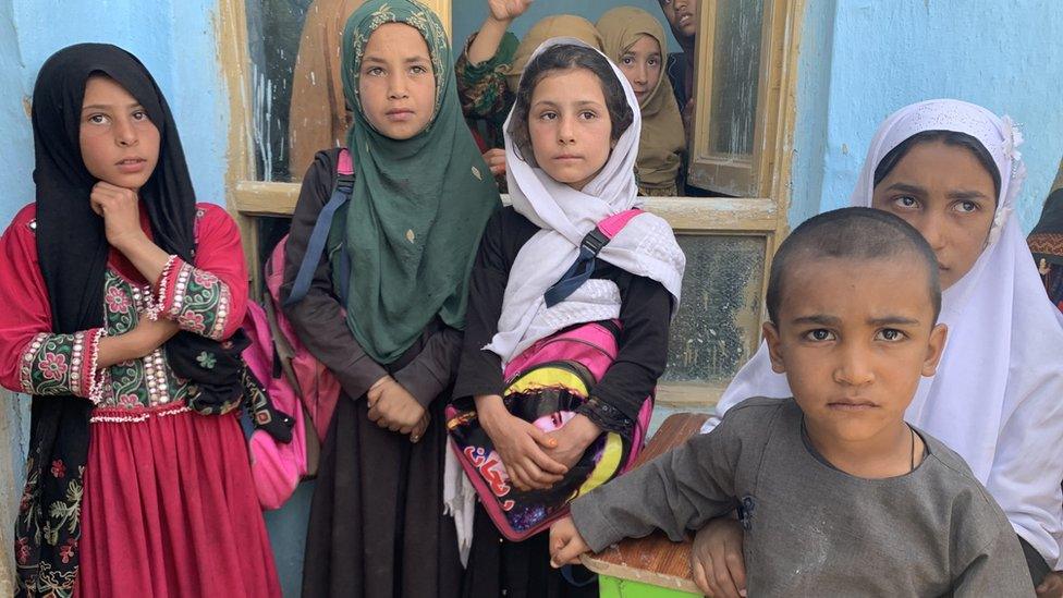 Children stand outside a community school