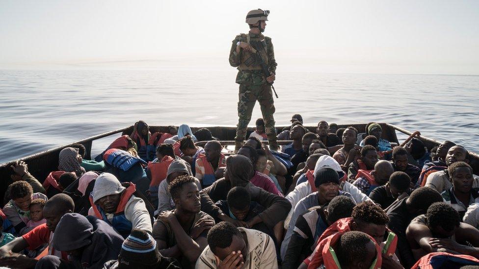 A Libyan coast guardsman stands on a boat during the rescue of migrants - archive shot 2017