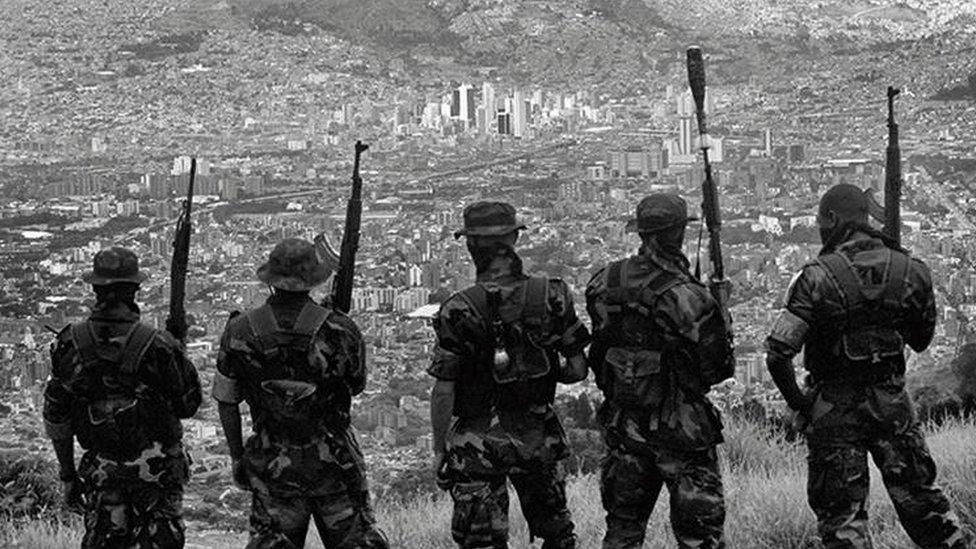 Paramilitaries watch the city of Medellin, the capital of Antioquia, from the mountains above