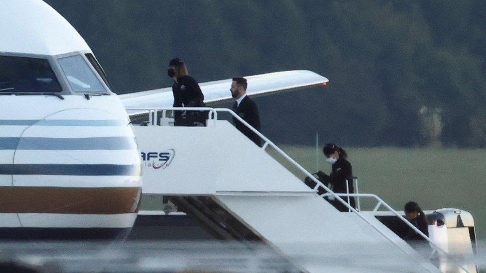 Members of the staff board a plane reported by British media to be first to transport migrants to Rwanda