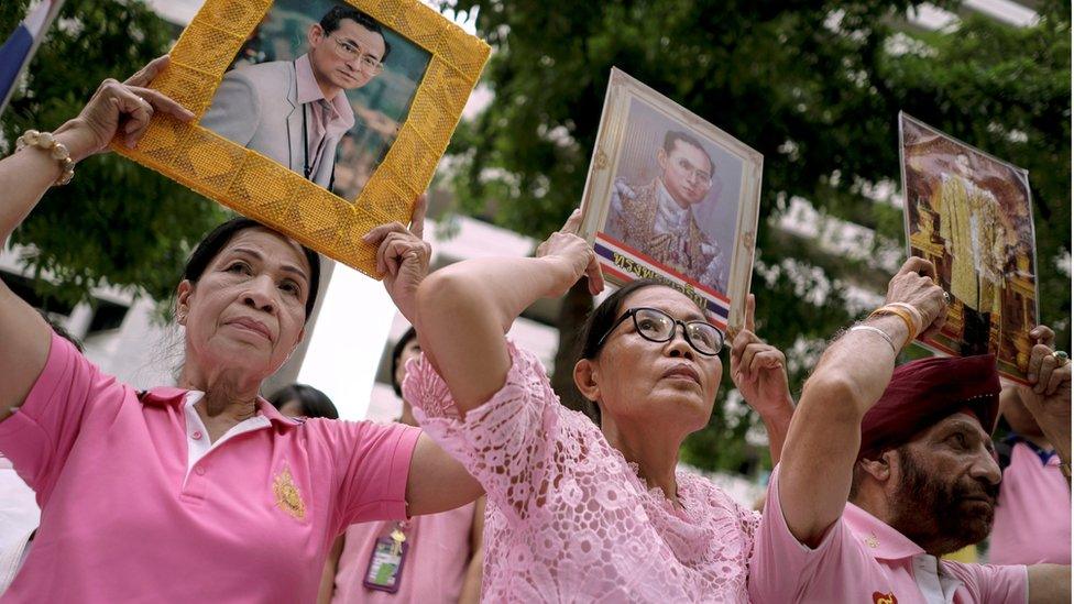 Well-wishers hold pictures of Thailand's King Bhumibol Adulyadej as they pray for him at the Siriraj hospital where he is residing in Bangkok, 12 October 2016