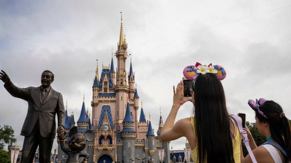 A statue depicting Walt Disney and Mickey Mouse in front of the Cinderella Castle at Disney World's Magic Kingdom on Saturday, June 3, 2023 in Lake Buena Vista, Fla.