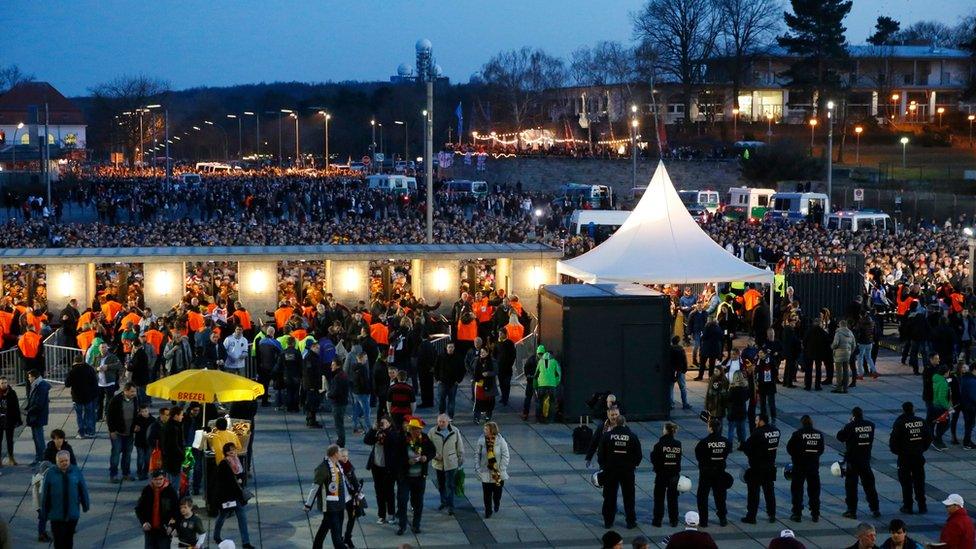 Fans pass through security as they enter the stadium before friendly