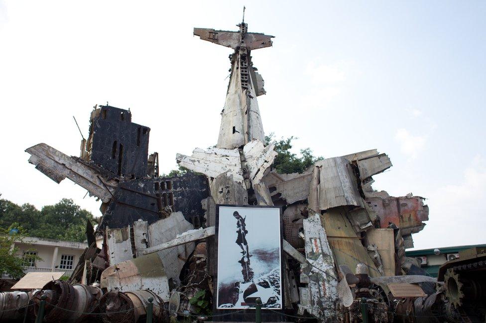 A sculpture made from wreckage of planes, with an image of a female fighter