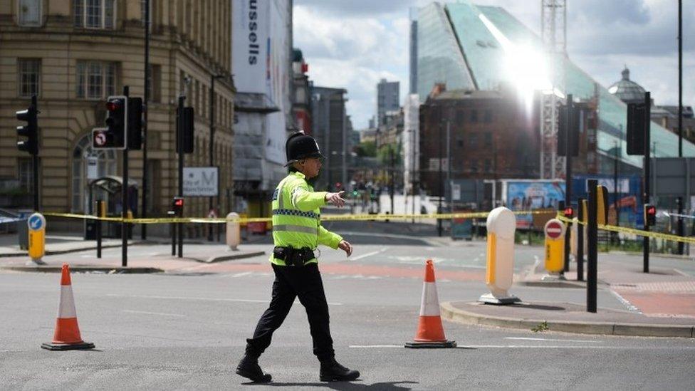 A police officer patrols a cordon near to the Manchester Arena