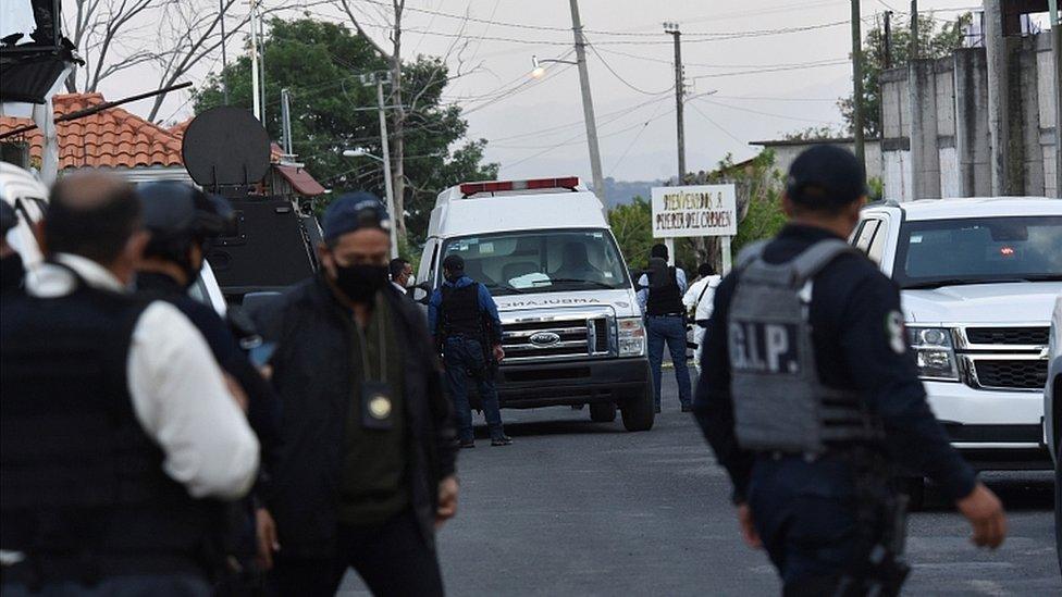 An ambulance is surrounded by police officers at a crime scene where gunmen killed at least 13 Mexican police officers in an ambush, in Coatepec Harinas, Mexico March 18, 2021