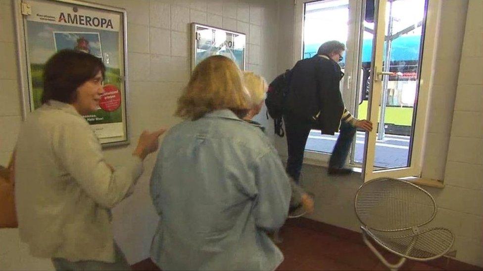 A passenger in Bad Bentheim climbs through a station to window to get onto the platform.