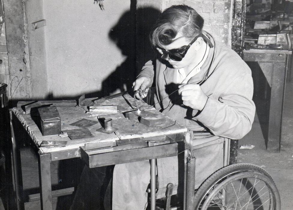 A man in a wheelchair soldering