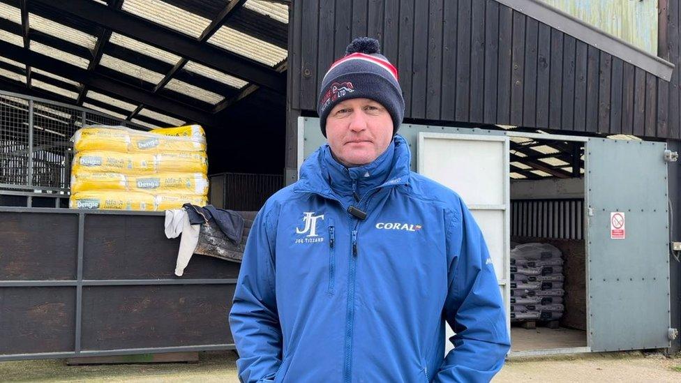 Man stood in front of the stable