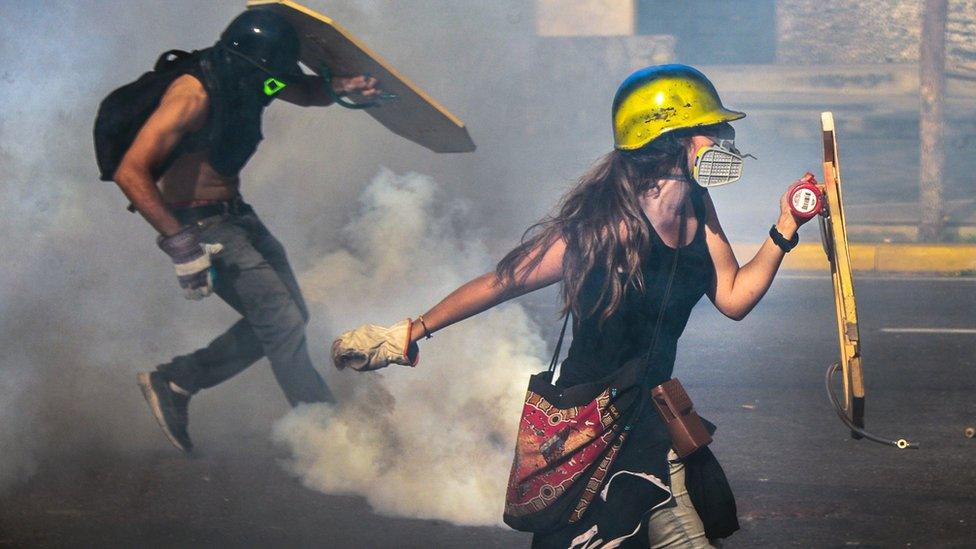 Venezuelan opposition activists clash with the riot police during a rally against the government of President Nicolas Maduro, in Caracas, 18 May