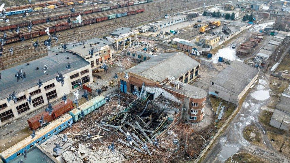 Damaged buildings and disused trains pictured in a rail yard in Lyman, Ukraine